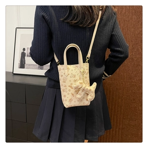 Détail du petit sac bandoulière avec imprimés ours et pendentif chien en peluche