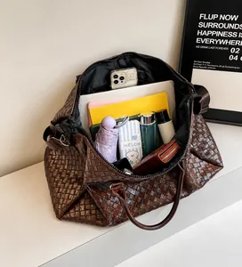 Detail of spacious dark brown woven travel tote showing laptop and accessories storage