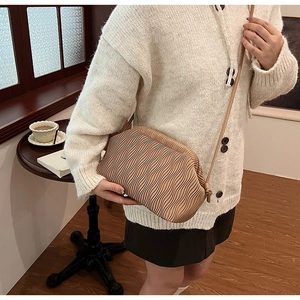 Details der karamellfarbenen Falten-Cloud-Bag an einem Model in einem Vintage-Zimmer