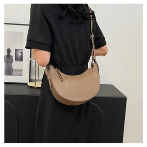 Dettaglio della borsa a mezzaluna kaki con tracolla larga vista sul retro del modello