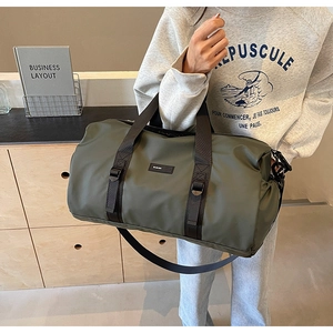 Army green large capacity travel duffel bag held by hand, durable nylon material details
