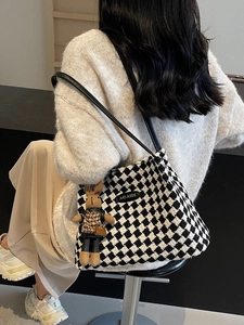Chic black and white checkered knit tote bag with elegant shoulder straps and rabbit charm