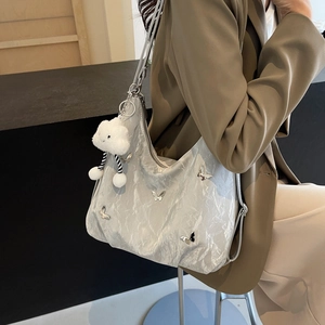 Silver metallic pleated large shoulder bag with butterfly charms and plush pendant