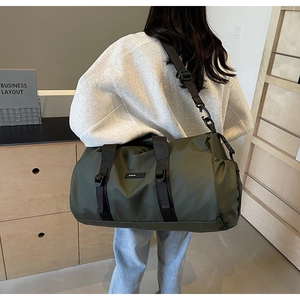 Close-up of military green Oxford cloth travel bag with adjustable black shoulder strap