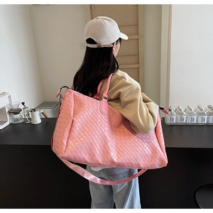 Detailed view of pink woven leather texture on a large travel tote with adjustable strap