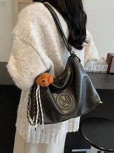 Retro black leather hobo shoulder bag with M logo and plush teddy bear pendant