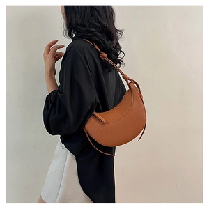 Vista dettagliata della borsa a mezzaluna in pelle marrone con tracolla a nodo elegante