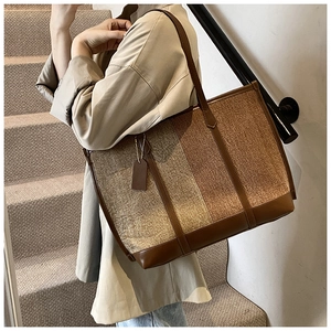 Detail of large tricolor patchwork tote bag with high-end leather trim and textured canvas