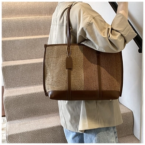 Detail of wool felt and leather tote bag featuring contrast stitching and textures