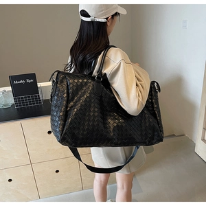 Detail view of woven black tote bag featuring large capacity and detachable shoulder strap