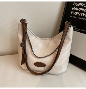 Close-up of white lychee pattern hobo bag featuring silver chain and brown leather strap