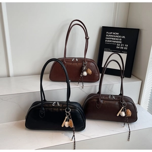 Close-up of minimalist bowling bags in black, mahogany, and dark coffee with sports charms