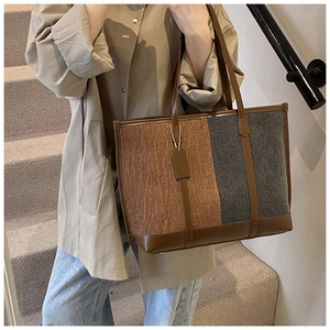 Close-up of contrast color tote bag with brown leather handles and felt texture
