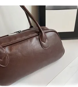 Close-up of high-quality dark brown leather texture and smooth silver zipper on retro bag