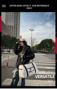 Street style λήψη μιας μεγάλης λευκής νάιλον τσάντας ταξιδιού με μαύρους ιμάντες και λογότυπο