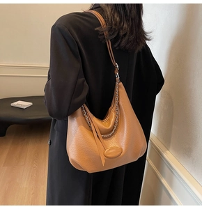 Dettaglio borsa hobo in pelle martellata marrone con catena argento e tracolla