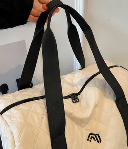 Detalle de bolsa de viaje acolchada blanca con asas negras y cierre de cremallera doble