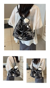Detailed views of a black textured tote bag with wave embroidery and cloud charm detail