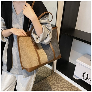 Detail of khaki and grey canvas tote bag with brown leather trim and hanging tag