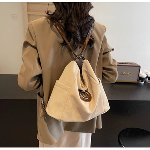 Detailed back view of a beige shoulder bag with a brown leather strap and M logo charm