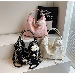 Detailed macro shot of three casual tote bags in pink black and white with cute charms