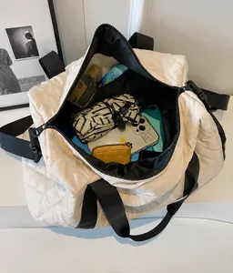 Vista interior del espacioso bolso de viaje blanco acolchado con artículos esenciales