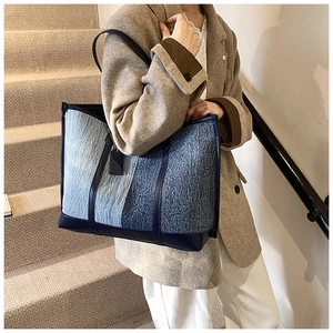 Close-up of contrast denim patchwork tote bag with leather straps on model's shoulder