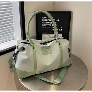 Detailed close-up of large travel bag with dual handles and wide nylon shoulder strap