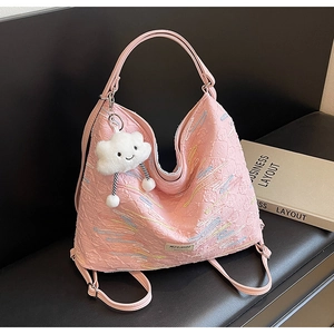 Detail of pink tote bag showing wavy embroidery and cute cloud plush keychain accessory