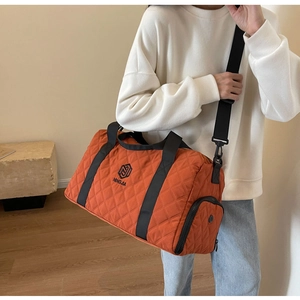 Dettaglio borsa da viaggio trapuntata arancione con scomparto scarpe e logo