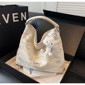 Detail of white tote bag with wave embroidery, cloud charm and luxury gift box setup