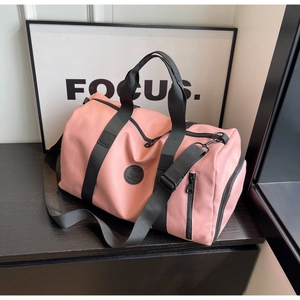 Gros plan du sac de voyage en nylon rose montrant le compartiment latéral pour chaussures