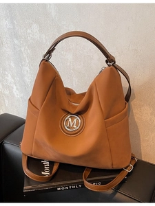 Brown large capacity tote bag with M logo, featuring dual straps and casual street style