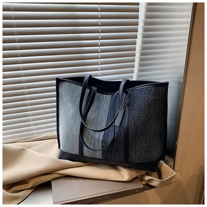 Detail of a large contrast color canvas tote bag with leather trim on a stylish windowsill
