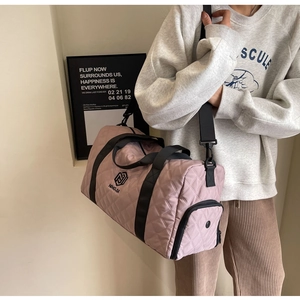 Borsa da viaggio trapuntata rosa indossata da modella come borsa a tracolla alla moda