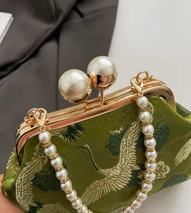 Detail of green silk embroidery bag with crane pattern and oversized pearl clasp