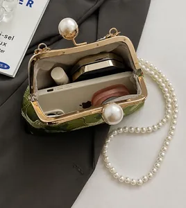 Detail view of green floral embroidery handbag showing spacious interior for phone and makeup