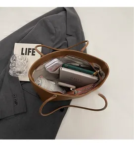 Top view of brown leather tote showing spacious interior with laptop and umbrella
