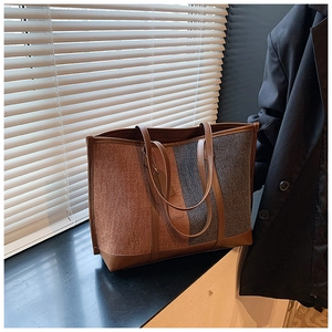 Detail of felt tote bag featuring brown leather trim and stylish tricolor panel design