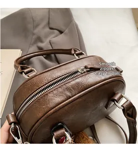 Close-up of the smooth silver zipper and premium brown leather texture on a retro handbag