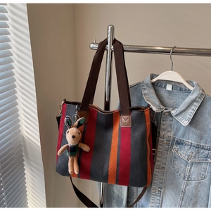 Detailed view of large canvas tote with red and orange stripes and a cute bunny charm