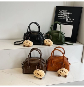 Detailansicht retro Boston Bags in vier Farben mit weißen Nähten und Plüsch-Anhängern