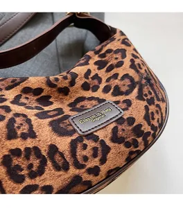Detail of leopard print handbag fabric texture and brown leather logo patch