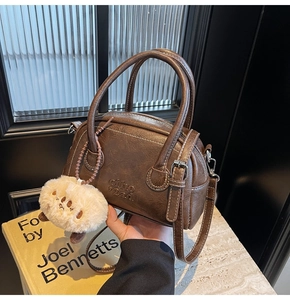 Detail der dunkelbraunen Boston Bag aus PU-Leder mit süßem Plüschtier-Anhänger