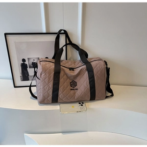 Dettaglio della borsa da viaggio trapuntata in nylon con logo e tracolla rimovibile
