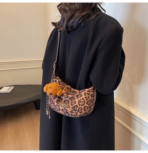 Detail of leopard print hobo bag with teddy charm and adjustable leather strap