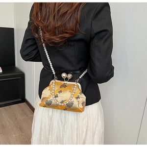 Detail of golden embroidery with crane and cloud patterns on the silk fabric handbag