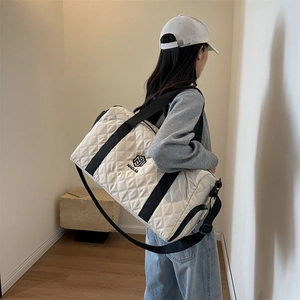Grande borsa da viaggio trapuntata bianca con manici neri e tracolla regolabile