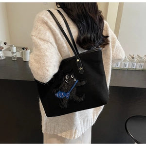 Detail of black tote bag with cute 3D cat embroidery and premium leather straps