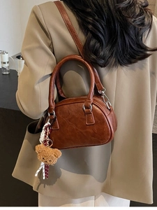Retro brown bowling style handbag for women with plush bear charm and crossbody strap